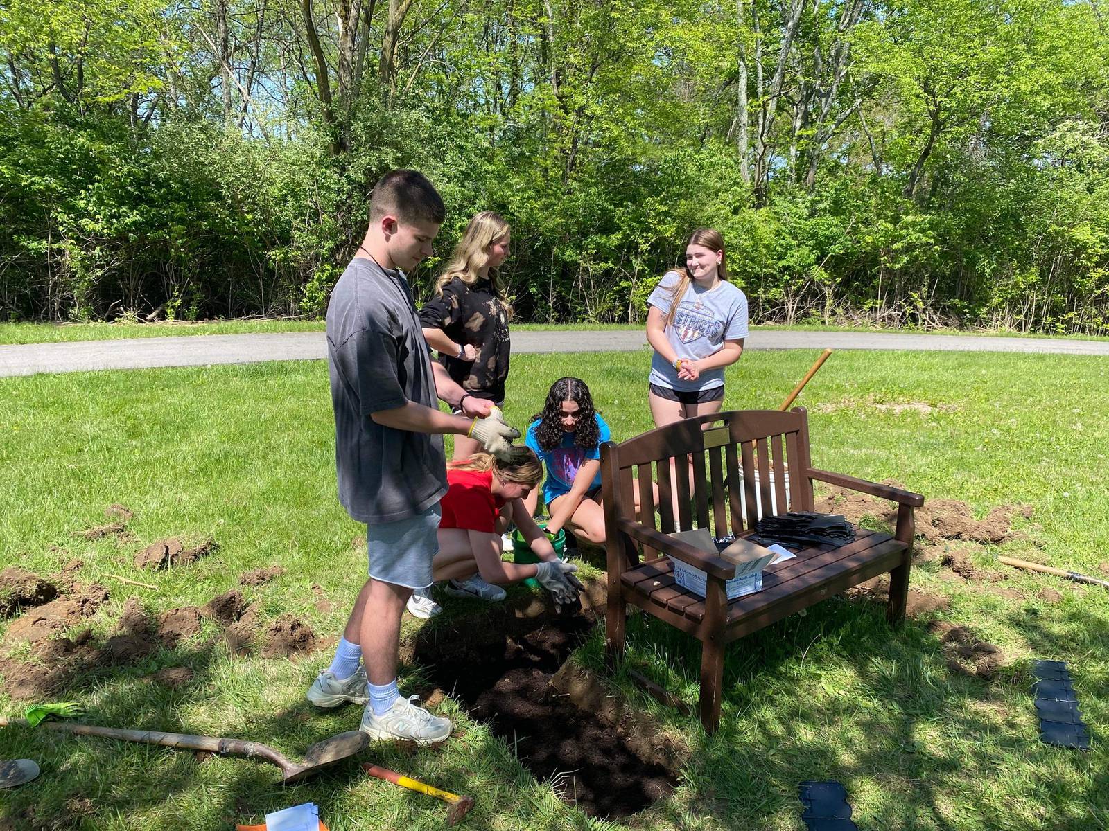 Fairborn HS students plant flowers around bench dedicated to 17year