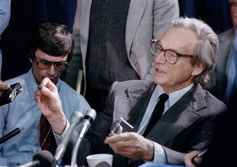 Richard Feynman, a Nobel physicist and a member of the presidential commission investigating the Space Shuttle accident, shows reporters a demonstration he tried putting a piece of the shuttle "O-ring" in a cup of ice water for a few seconds, causing as he said "No resilience in this particular material" when the temperature reached 32 degrees, Feb. 11, 1986. Feynman raised the possibility that cold, pre-launch weather might have figured in the failures in the seal. Feynman talked to reporters at a lunch break of the commission meeting in Washington. (AP Photo/Scott Stewart)