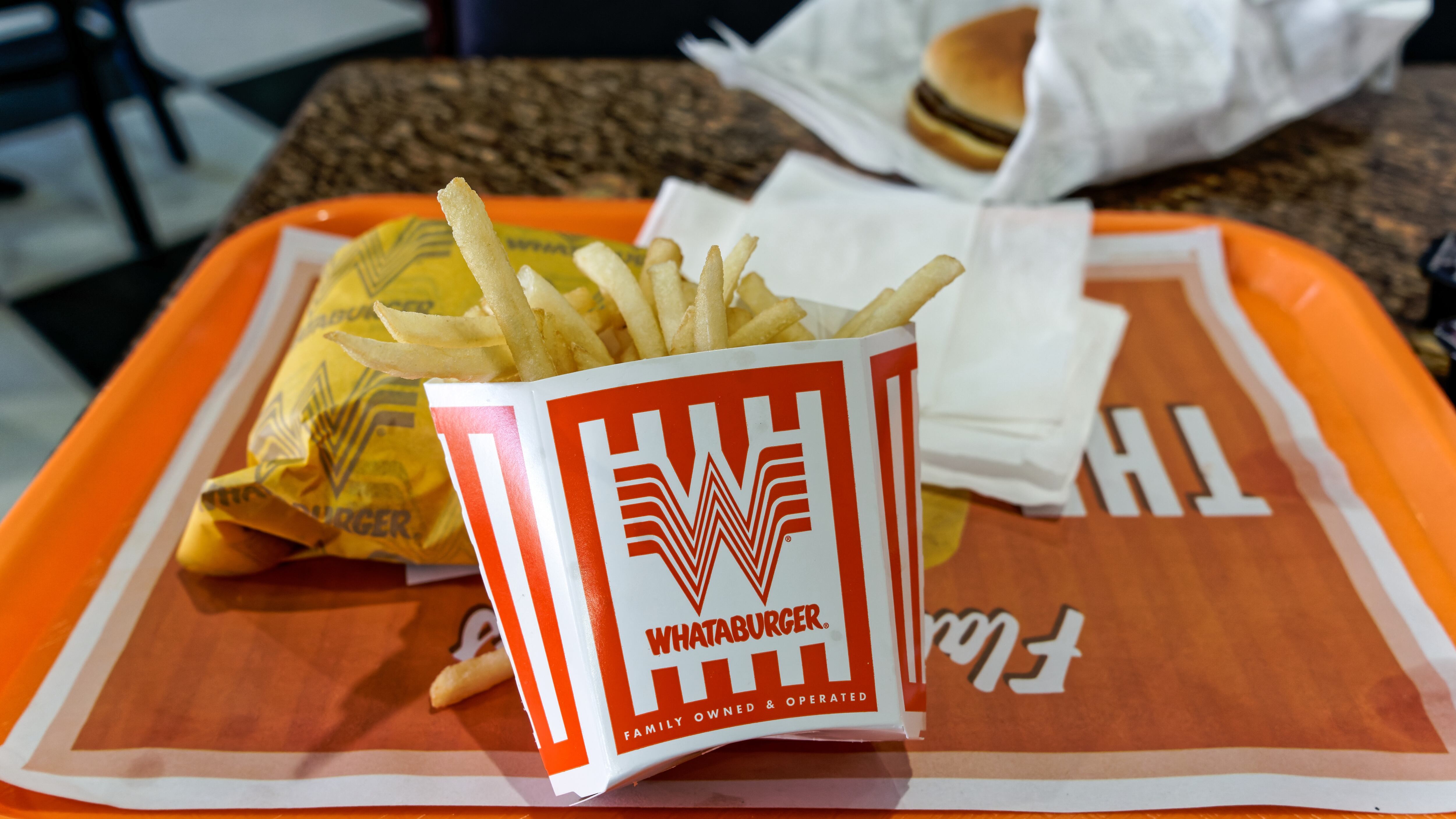 Whataburger meal on a tray with selective focus on the french fry container.