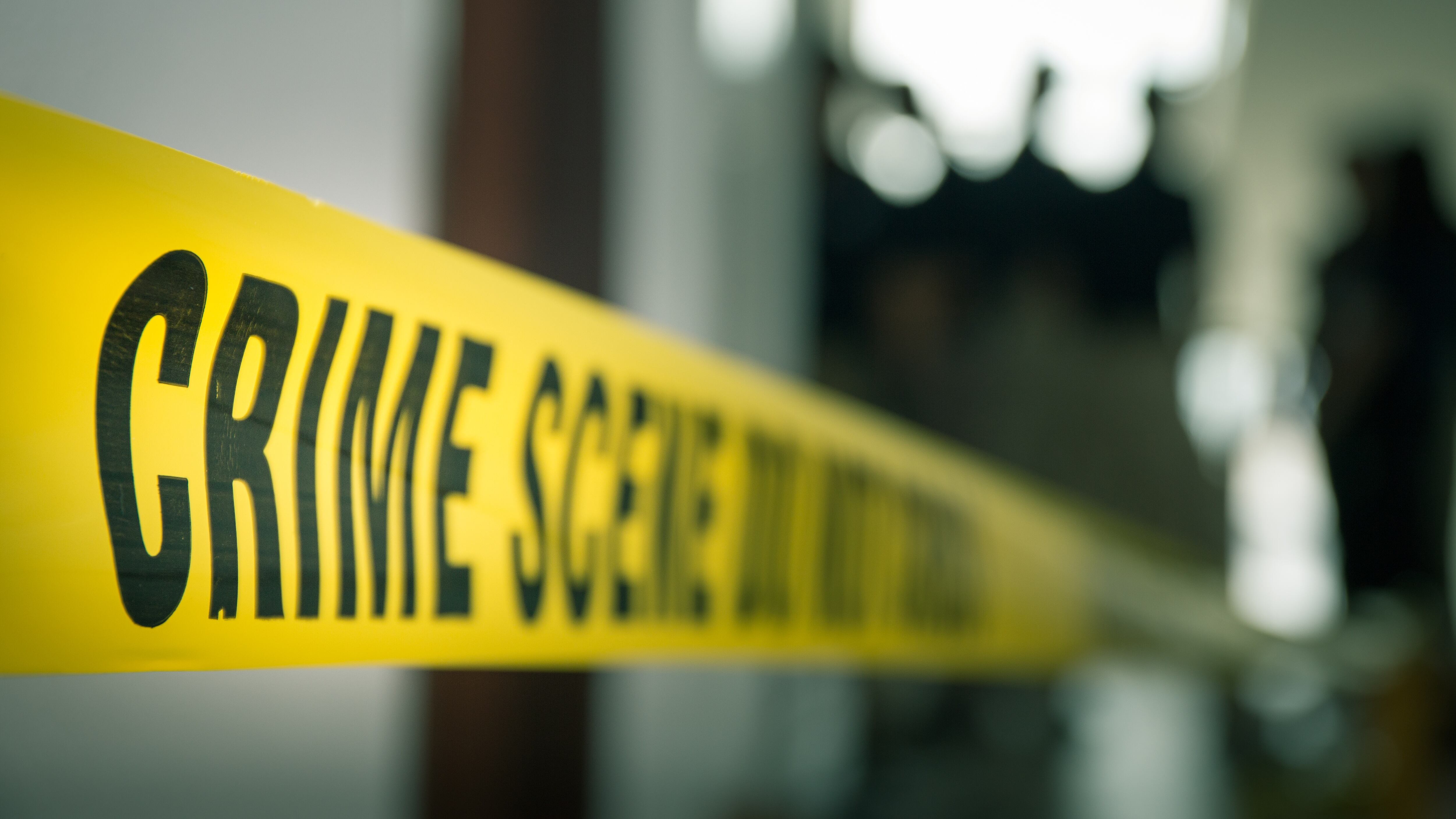 crime concept by police line tape with blurred forensic law enforcement background in cinematic tone and copy space